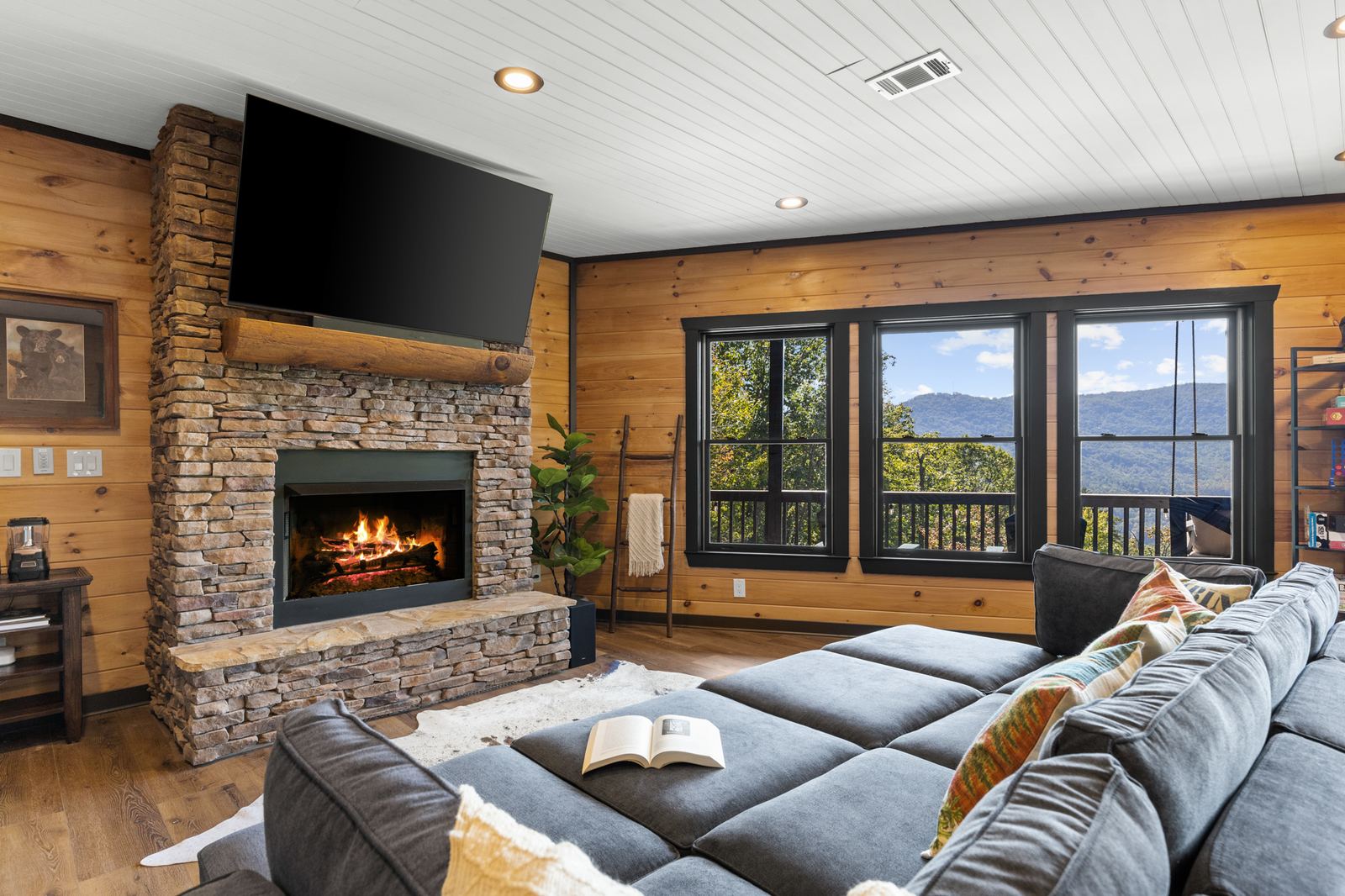 The lower living room's sectional and stone gas fireplace