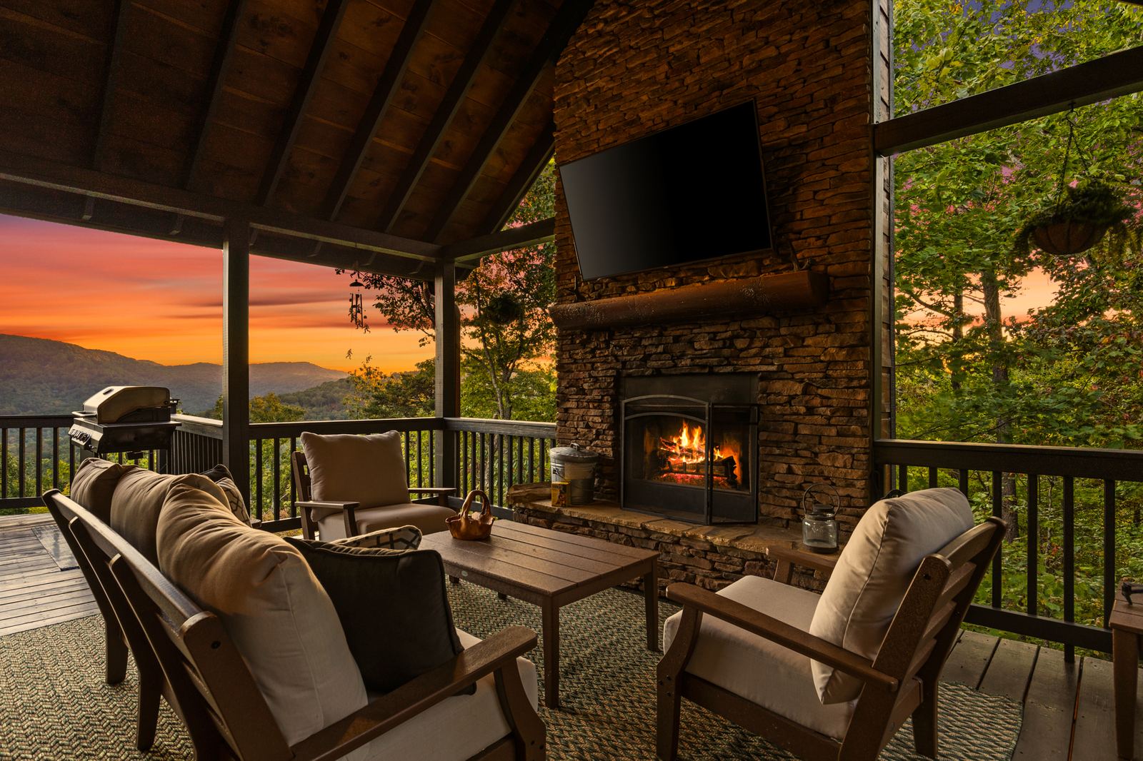 The covered front porch with its stone fireplace lit at dusk